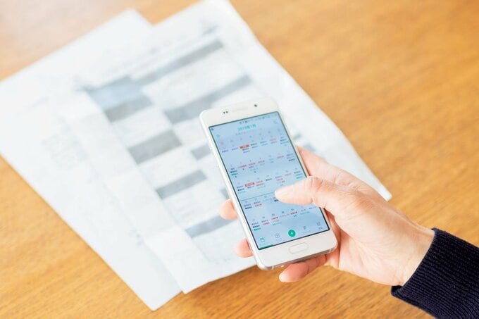 スマホでアプリに入力した家族の予定を確認する様子