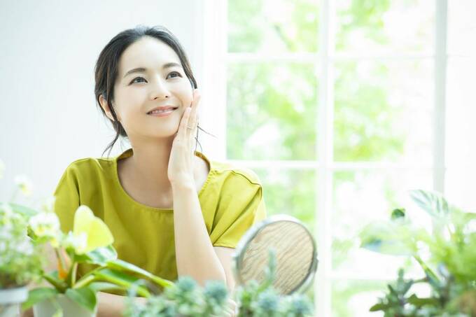 緑と頬をおさえる女性