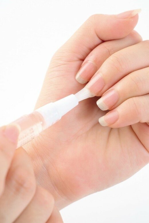 爪にネイルオイルを塗る様子