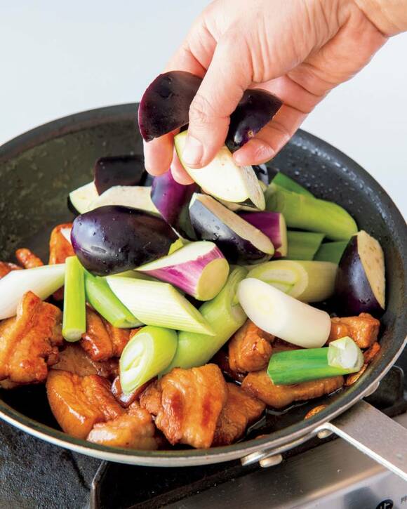 ナスと長ネギを加える様子