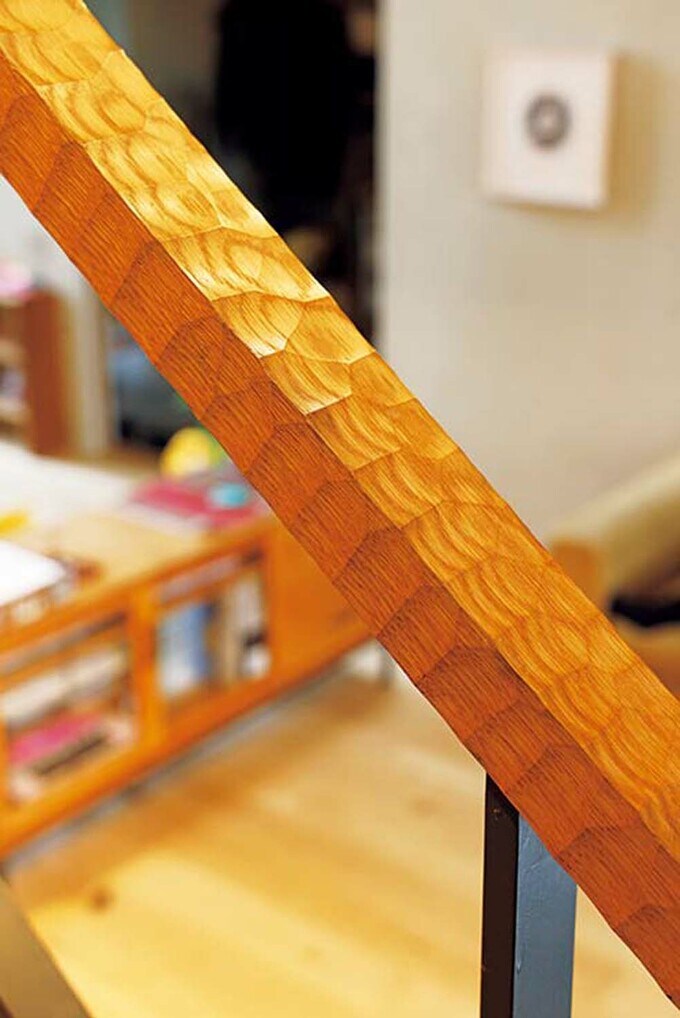 階段の木製手すりは、独特の削り痕を意匠とするなぐり仕上げに。