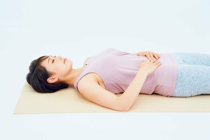 仰向けお腹に手