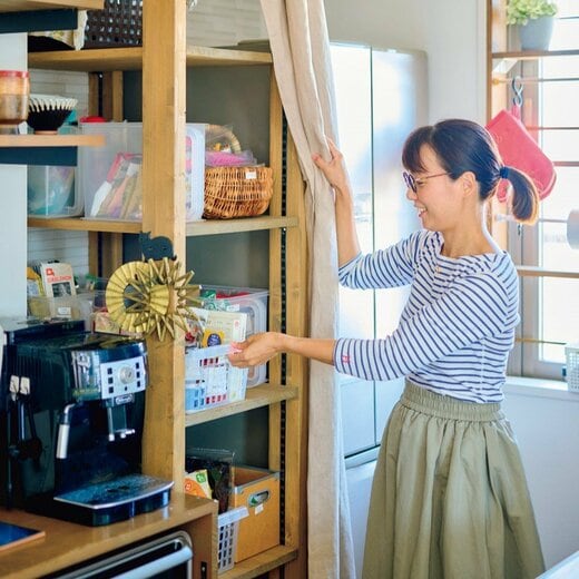 棚から収納箱を取り出す女性