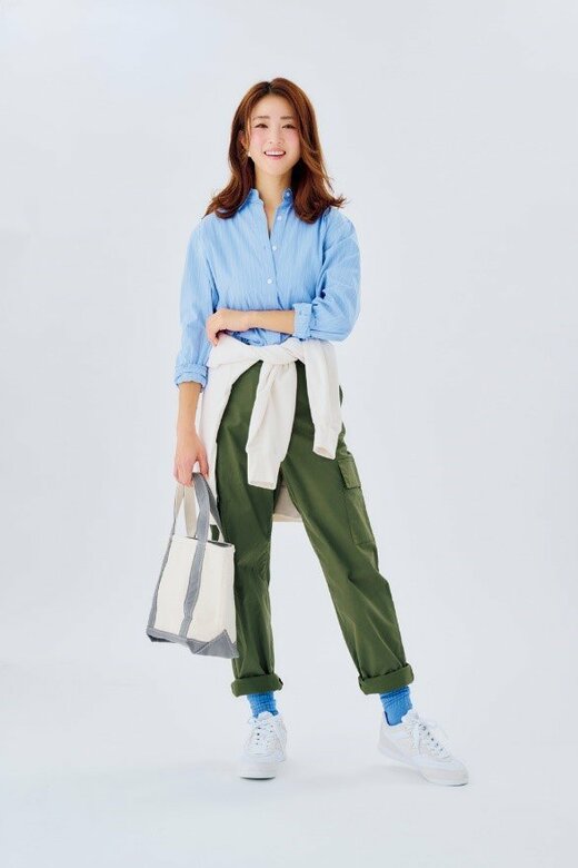 カバンを持って笑顔で立つ女性