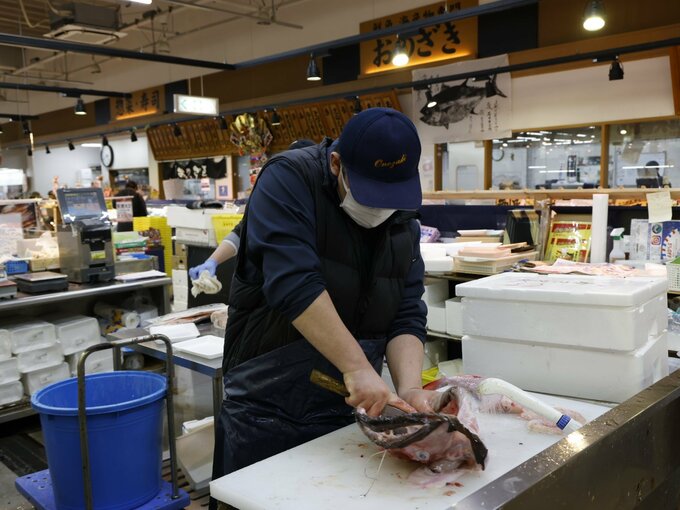 魚をさばく店員