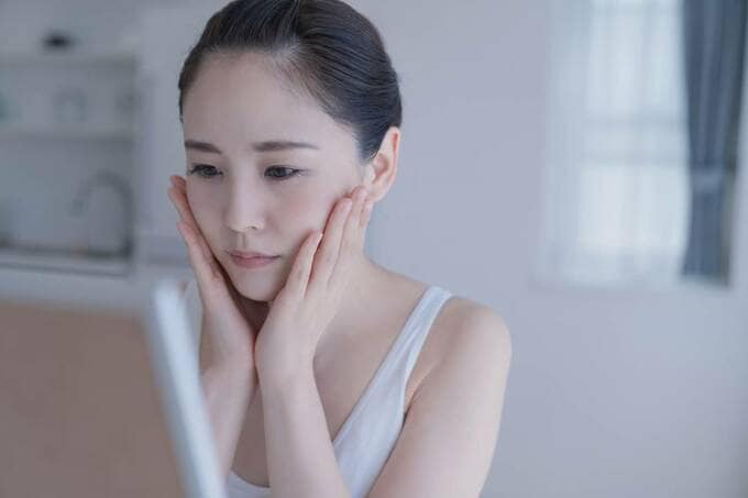 両手で頬を触る女性