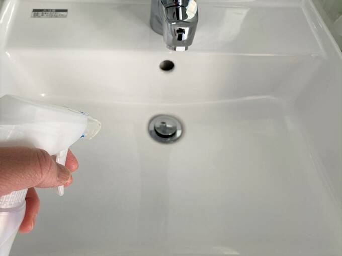 洗面台にスプレーをふきかける様子