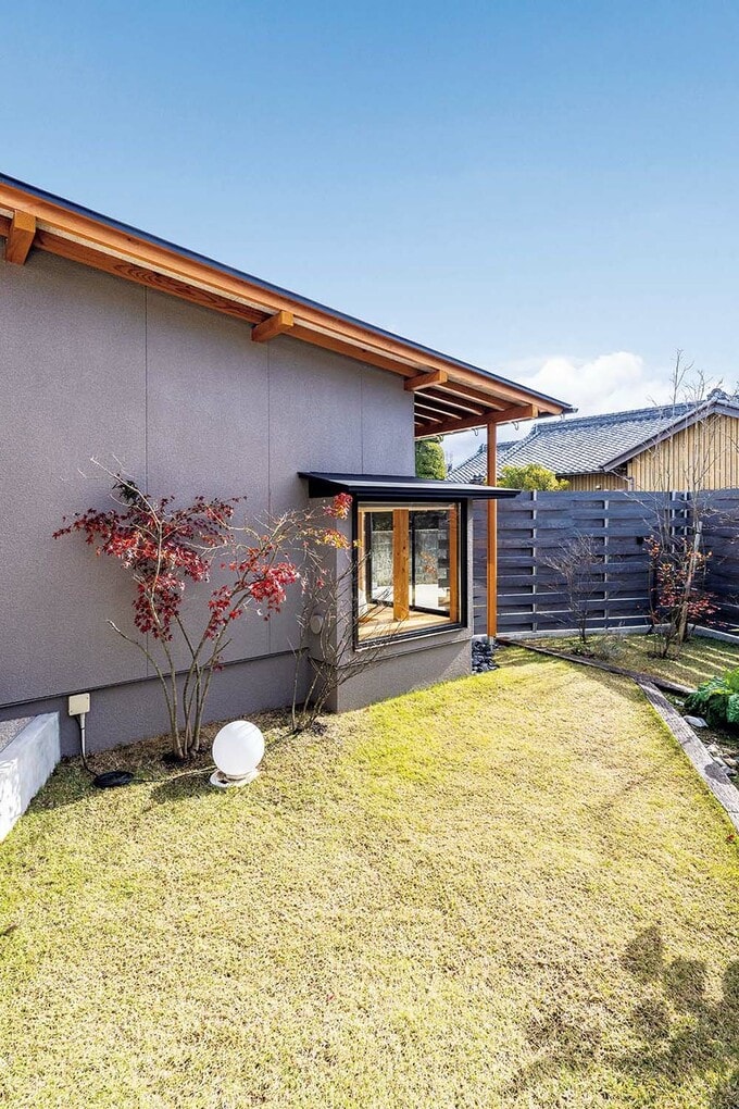 への字型の建物と木塀で囲われた南側の庭