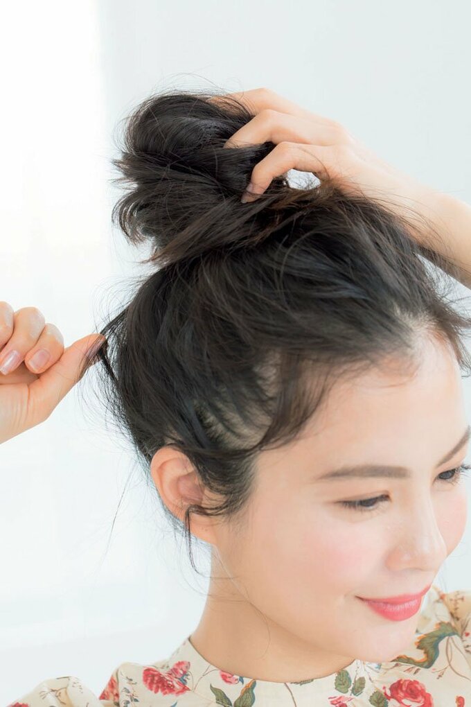 斜め前女性お団子ふんわりつまむ