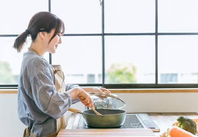 フライパンで調理中の女性