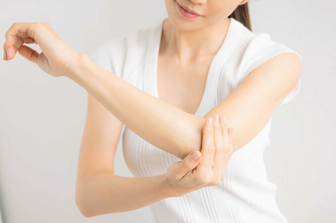 左ひじを触る女性