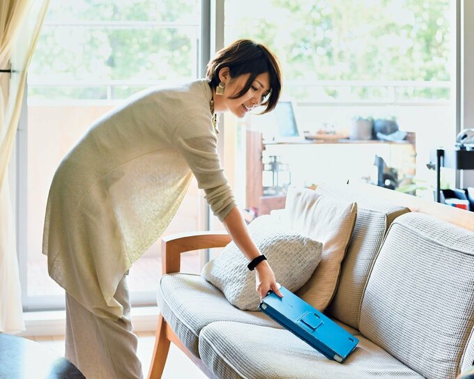 ソファの上の青のファイルを持つ女性