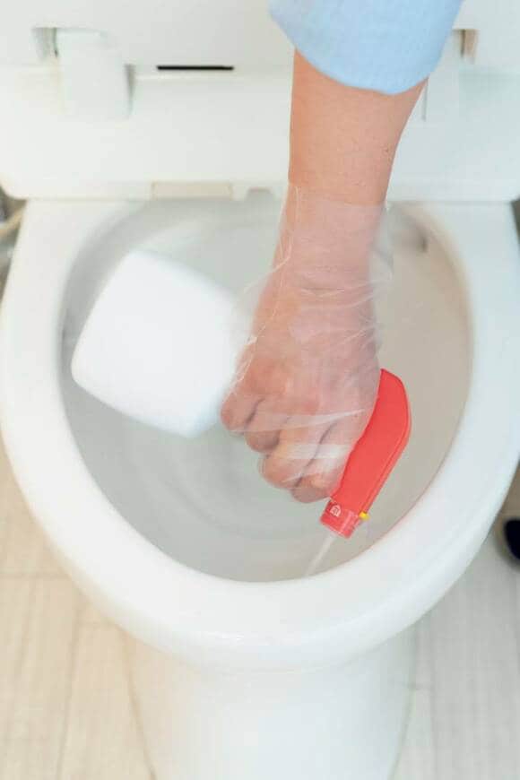 カビ取りスプレーを便器にスプレーする様子