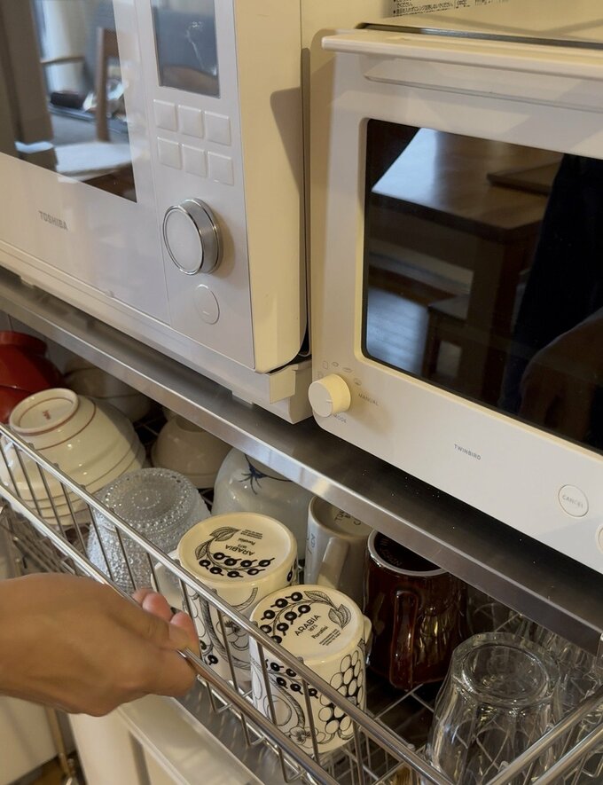 カップの入ったワイヤー製の引き出しを開けているところ