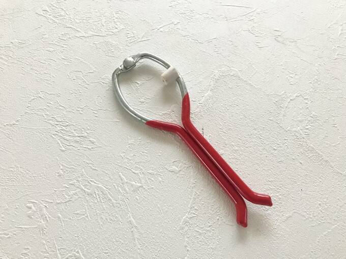 スプレー缶を挟むと横にある鋭い針で缶に穴があき、ガスが抜けます