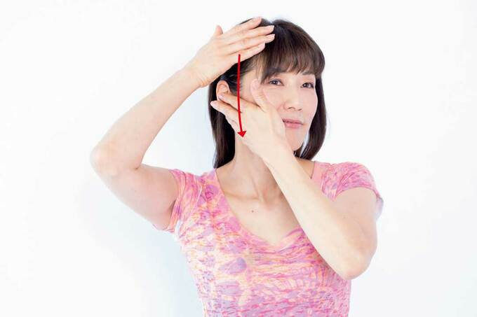 こめかみから下へなでる様子