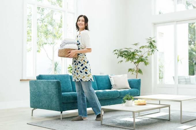 リビングに洗濯物を持つ女性