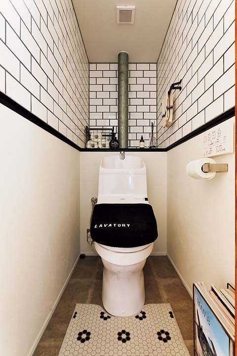 白いサブウェイタイルで壁を仕上げたトイレ