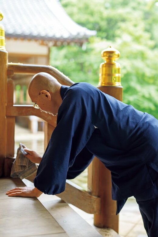 お寺の掃除をする住職