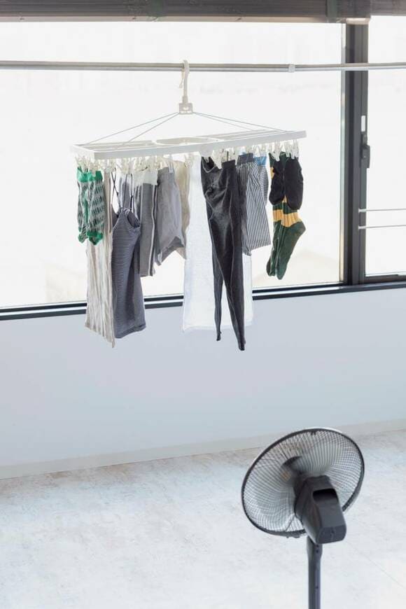 干した洗濯物の下から扇風機を当てる様子