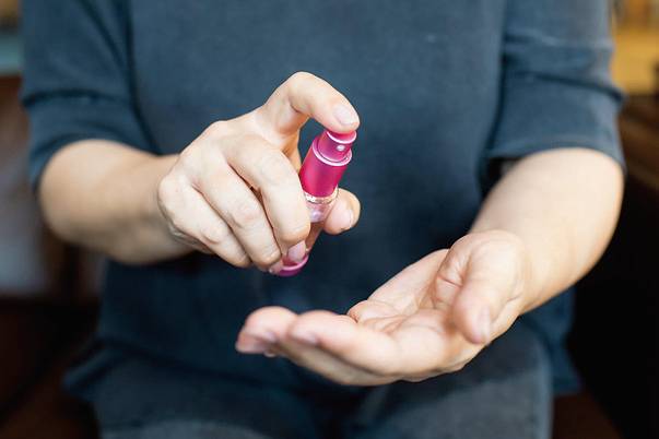 手にスプレーをする様子