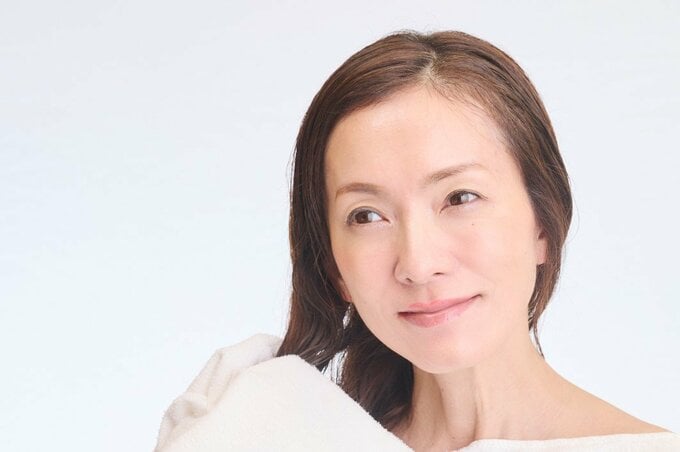 タオルで髪をふく女性