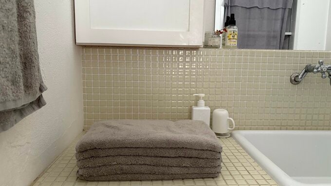 洗面所の台にタオルが積み重ねられている