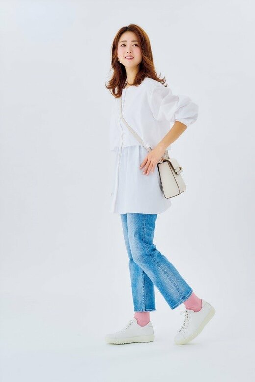 腰に手を当てて横向きに立つ女性