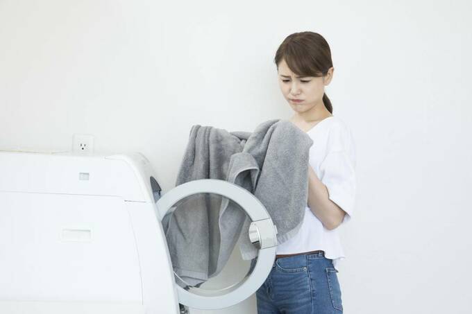 洗濯機から衣類を取り出した女性