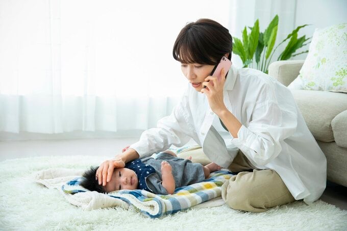 子育てしながら電話をする女性