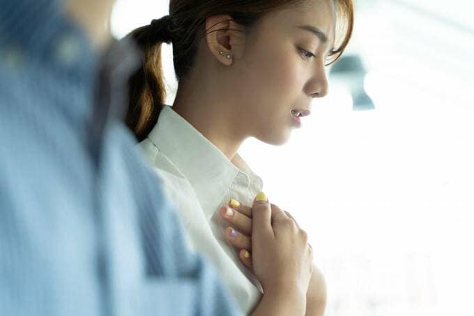 胸をおさえる女性