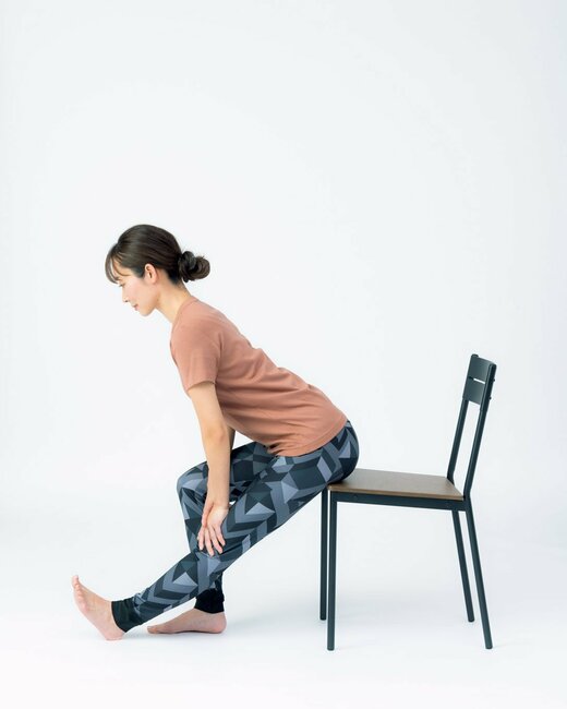 椅子に腰かけて上体を倒してる人