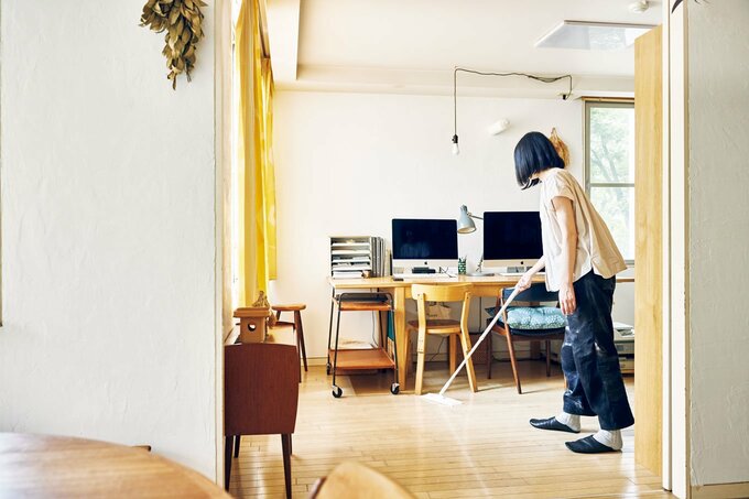 机の下を掃除する人