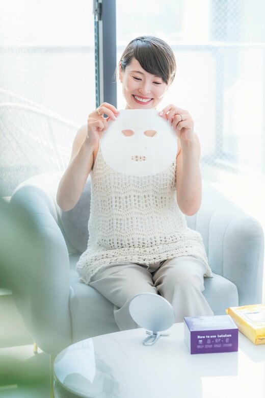 シートマスクを装着しようとする女性