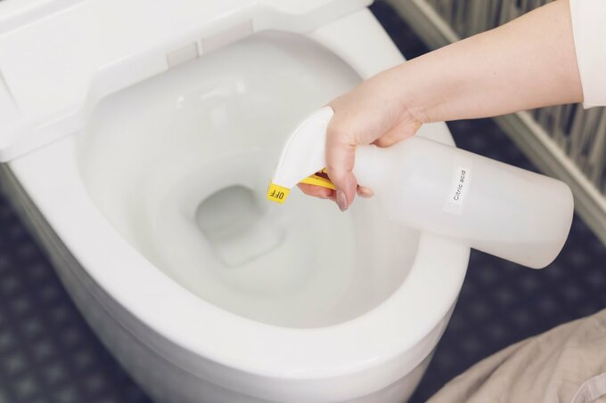 クエン酸スプレーをトイレに吹きかけている様子