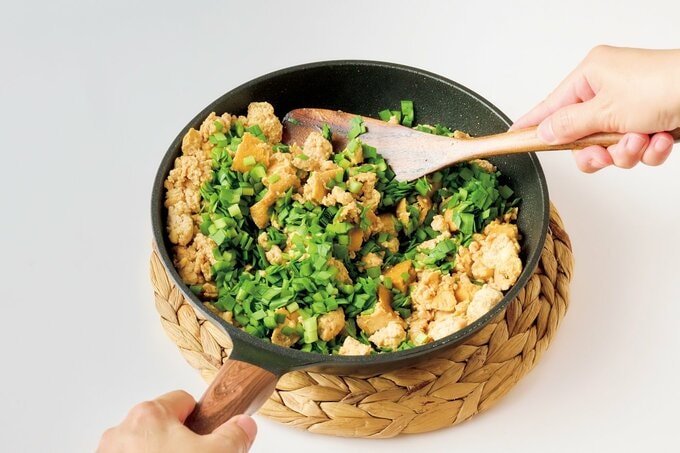 木べらで食材の入ったフライパンの中を混ぜる様子