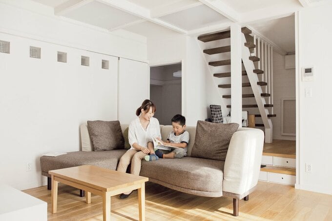 リビングで本を読む親子