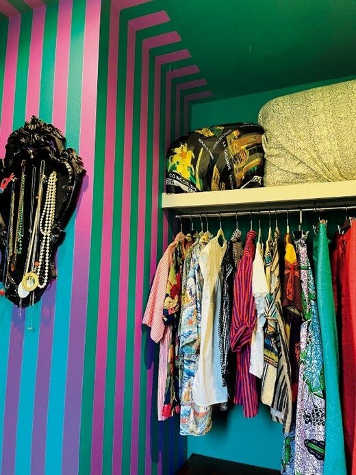 壁の一部がピンクとグリーンのストライプにペイントされたクローゼット