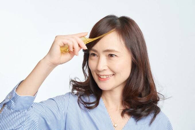 コームの柄で前髪を整える