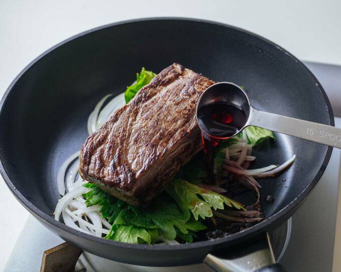 フライパンにお肉と野菜に調味料を加える