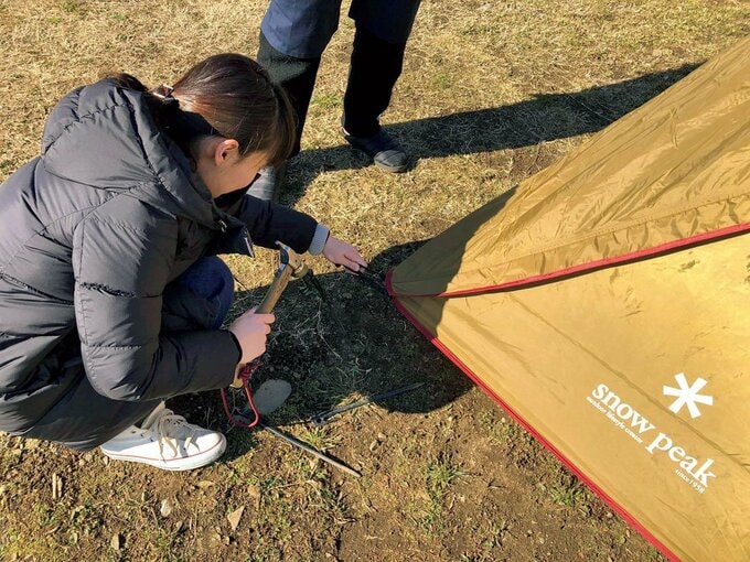 テントとしゃがんだ女性