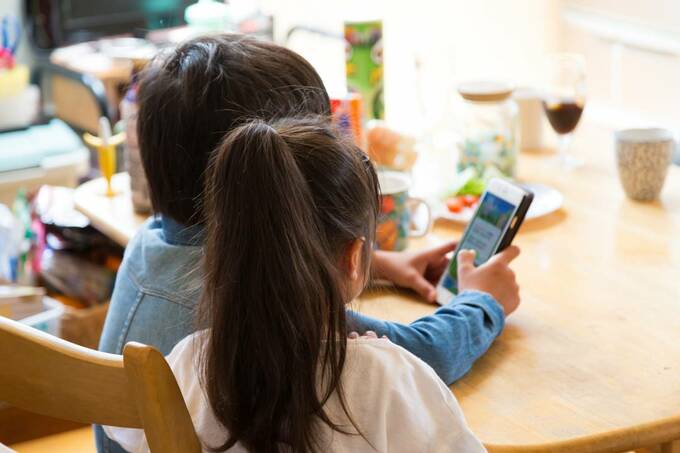 子どもがスマホを使っている様子の画像