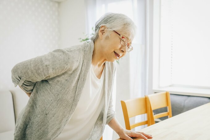 腰を痛がる女性