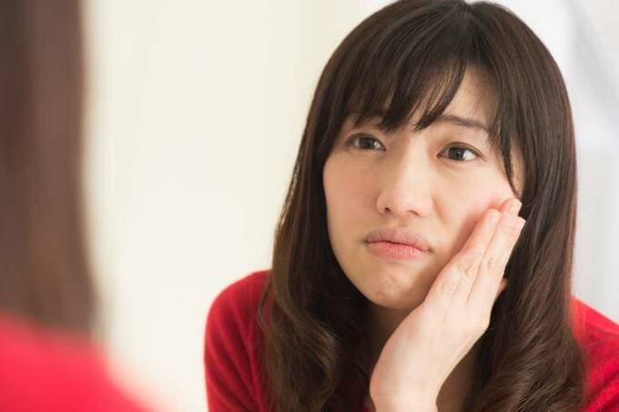 頬に手を当てている女性