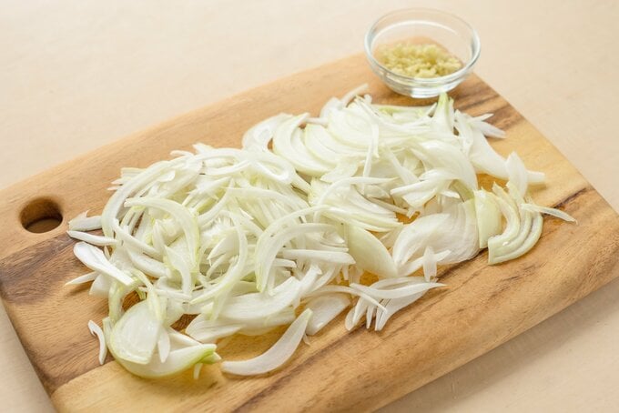 薄切りのタマネギがまな板にのっている
