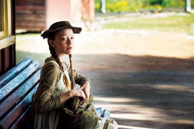 ベンチに座る帽子をかぶった女性