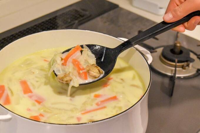 鍋に入ったスープをシリコン調理スプーンですくう