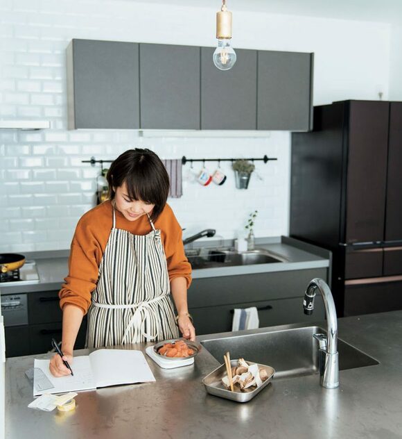 女性キッチンでレシピチェック