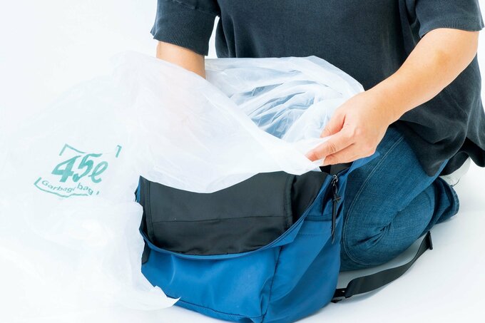 リュックを広げて袋を入れている