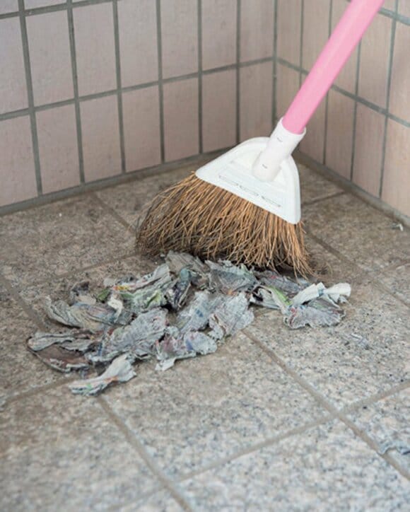 ちぎって濡らした新聞紙をホウキでかき集める